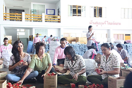 Miss Thailand Universe Chansorn Sakornchan (left) helps pack supplies for the Princess Pa Foundation to send to flood victims throughout the country.
